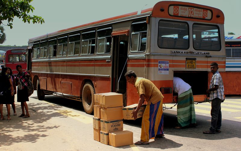 LANKA ASHOK LEYLAND BUS UNLOADS CARGO AT GALLE SRI LANKA JAN 2013